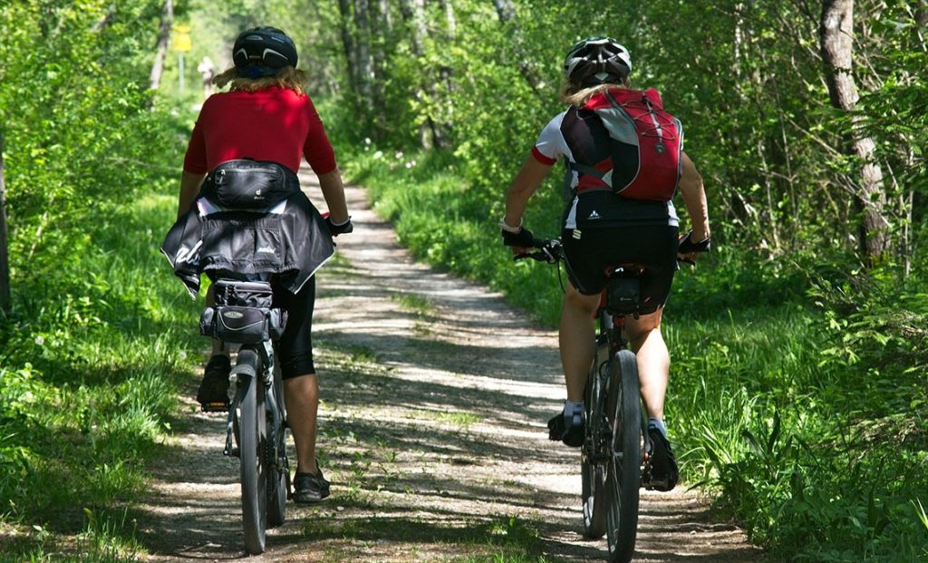 Två personer som cyklar i skogen.