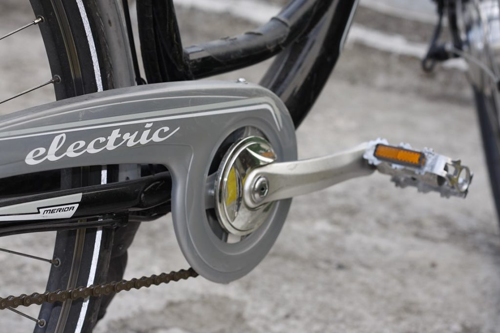 En närbild på pedalerna på en hybridcykel.